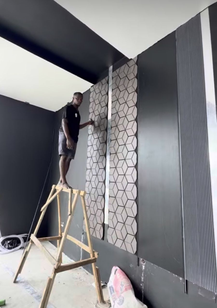 Black feature wall with hexagon and fluted panels being fitted